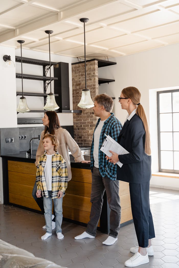 Home Family exploring a modern home kitchen with a real estate agent, showcasing buying opportunities.